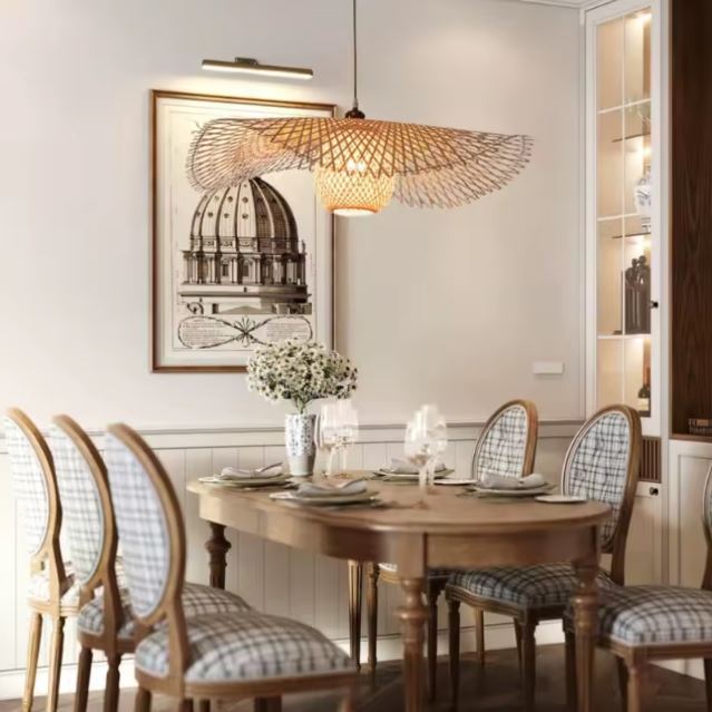 Suspension libellule en bambou au-dessus d’une table de salle à manger, luminaire naturel au style aérien et organique.