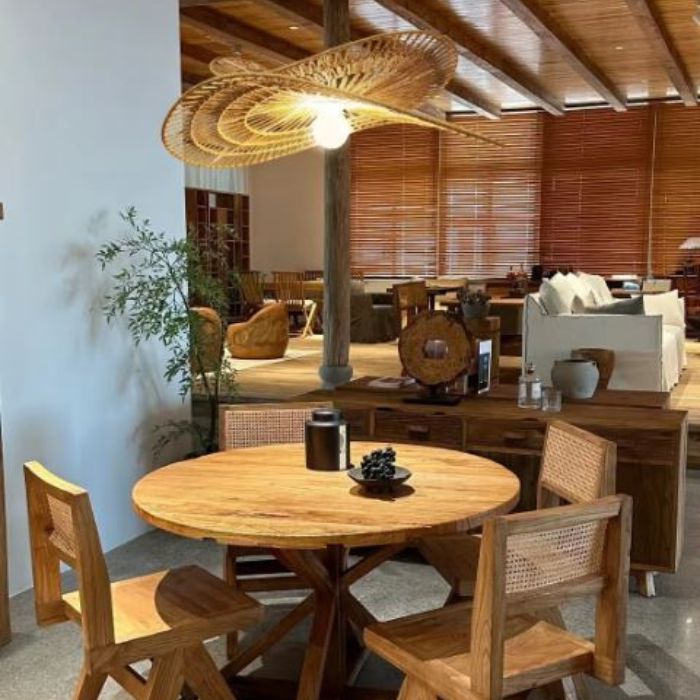 Suspension libellule en rotin naturel suspendue au-dessus d'une table rustique, idéale pour une salle à manger chaleureuse.