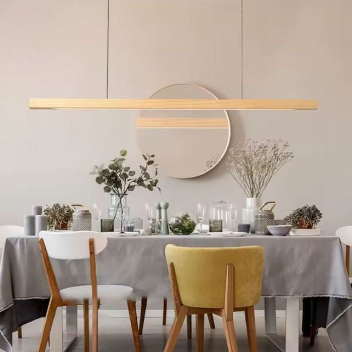 Suspension linéaire en bois clair avec LED intégrée, luminaire japandi minimaliste idéal au-dessus d’une table à manger.