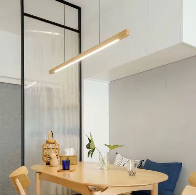 Suspension linéaire bois au design épuré, idéale pour éclairer un coin repas dans une cuisine moderne et lumineuse.