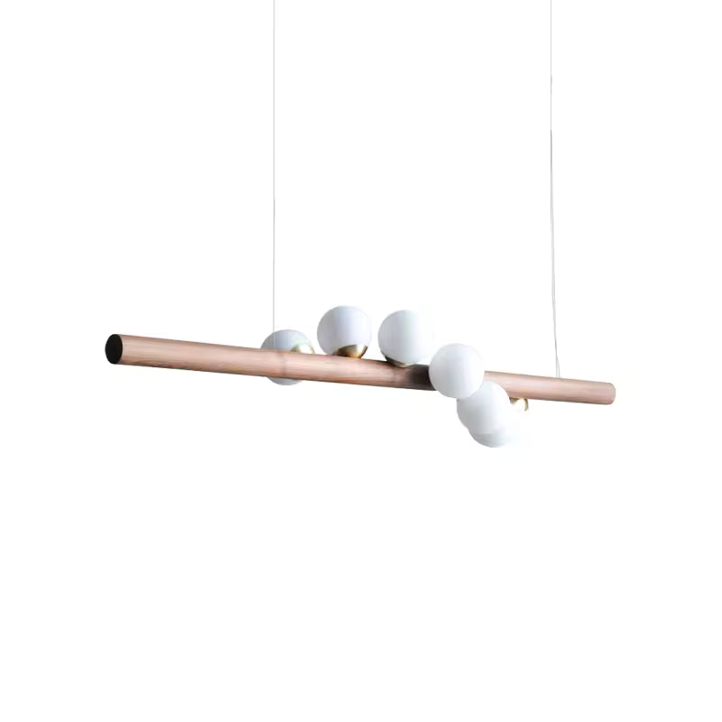 Barre en bois ponctuée de globes blancs pour une suspension linéaire au style japandi, organique et minimaliste.