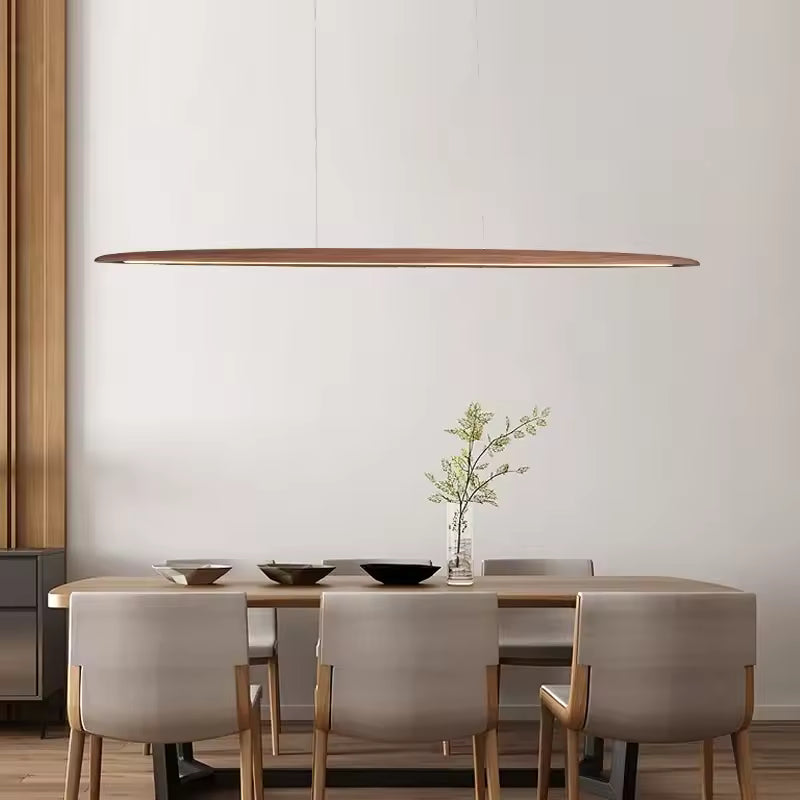 Suspension linéaire en bois à ligne effilée au-dessus d’une table, dans un intérieur minimaliste japandi