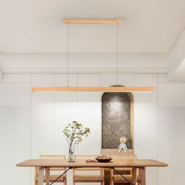 Suspension linéaire en bois naturel avec LED intégrée, luminaire scandinave épuré créant une ambiance douce et chaleureuse.