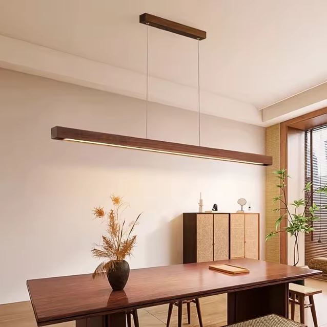 Suspension linéaire en bois noyer avec LED intégrée, luminaire design contemporain idéal pour une grande table à manger.