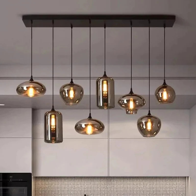Suspension linéaire moderne composée de multiples abat-jours en verre fumé aux formes variées.