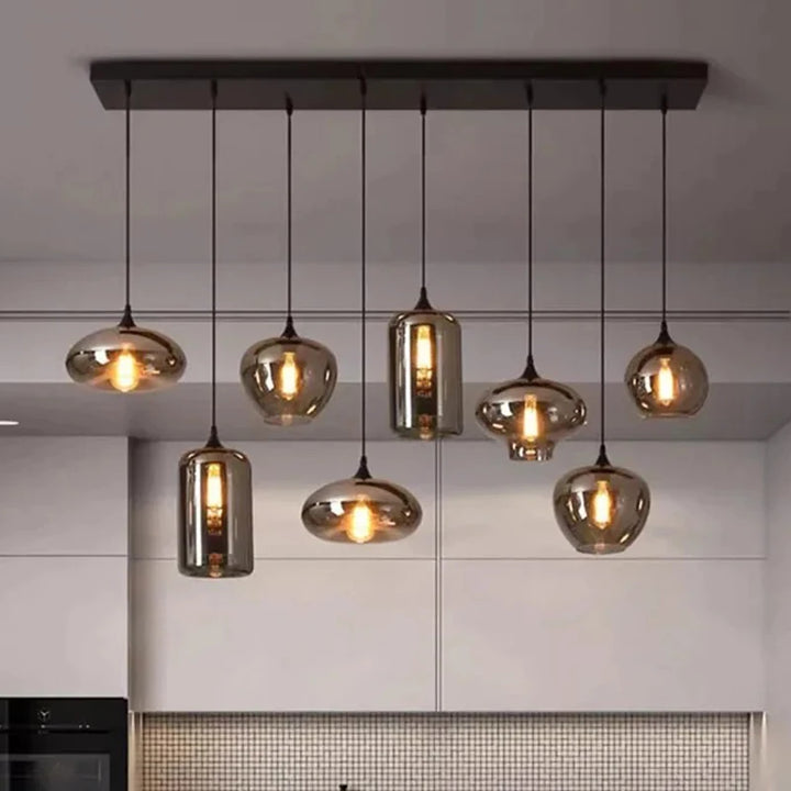 Suspension linéaire moderne composée de multiples abat-jours en verre fumé aux formes variées.