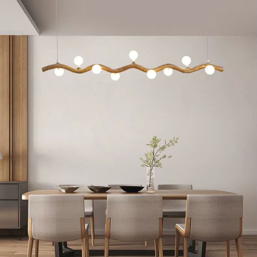 Une suspension aux courbes effet bois et globes lumineux surplombe une table à manger dans un décor scandinave épuré.