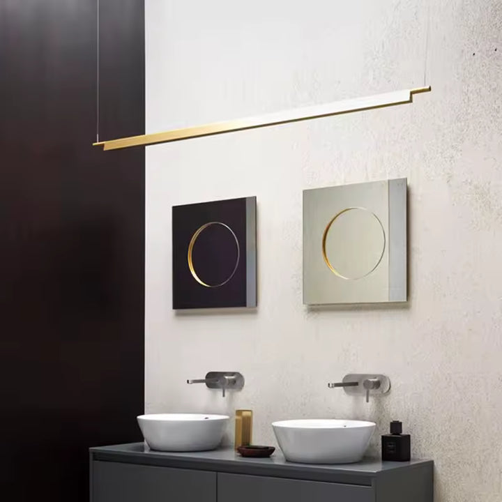 Suspension linéaire LED dorée au-dessus d’une vasque, dans une salle de bain moderne au style architectural