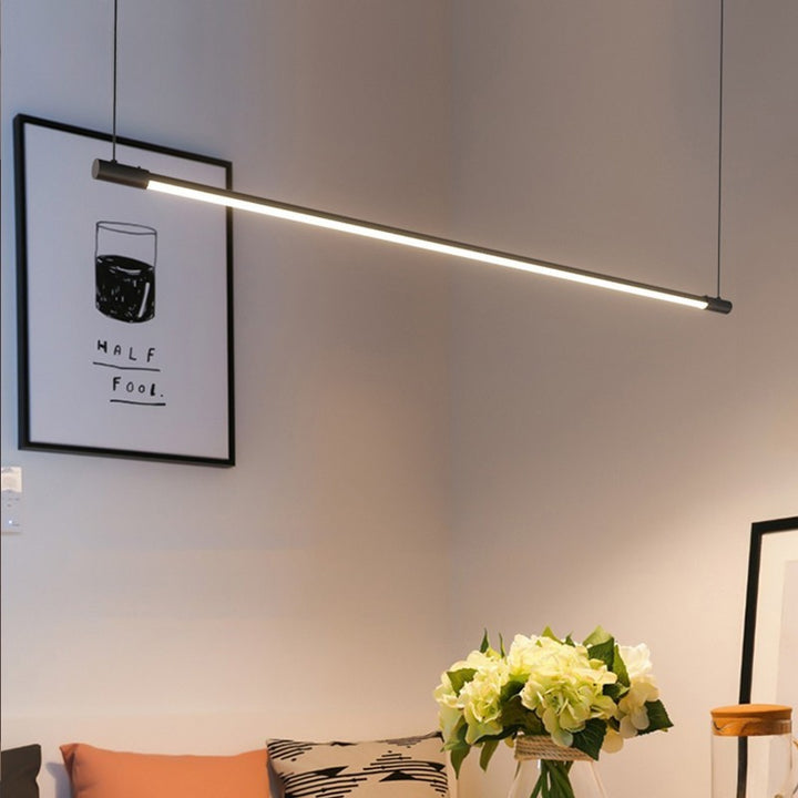 Luminaire suspendu tubulaire LED noir mat diffusant une lumière douce et moderne.