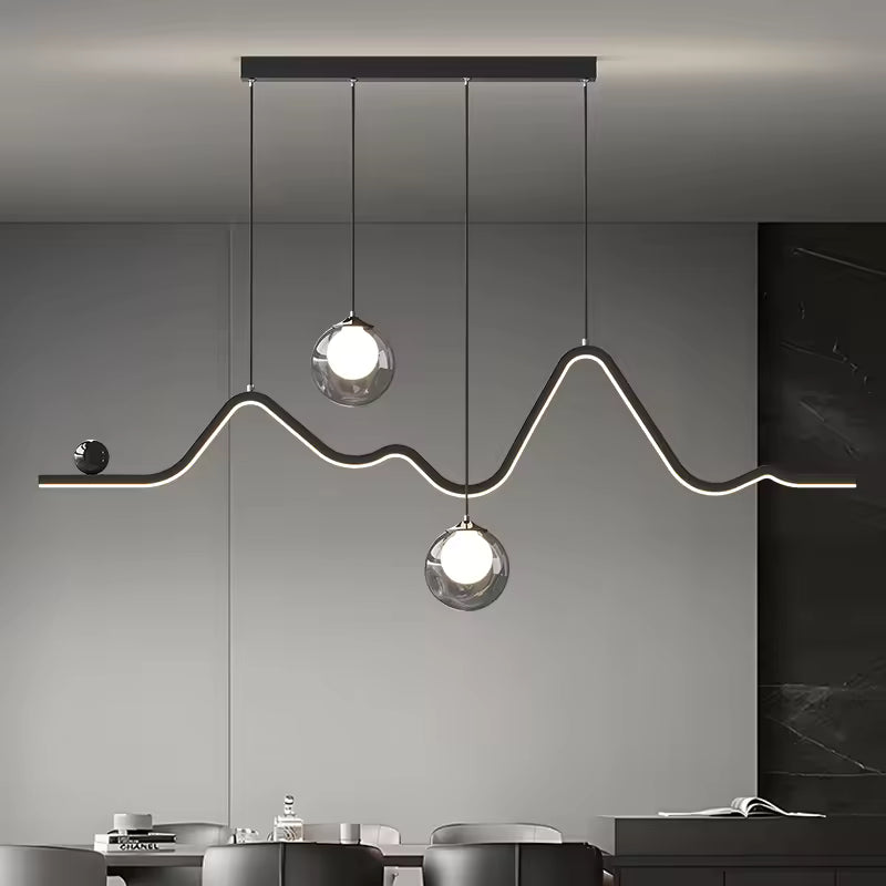 Au-dessus d'une table à manger, suspension graphique à ligne LED sinueuse et deux globes en verre au style contemporain.