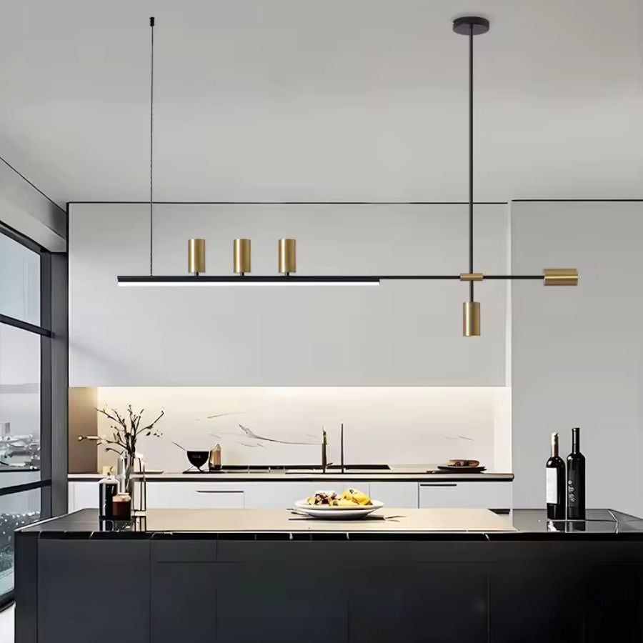 Suspension noire et dorée à silhouette linéaire et contemporaine, installée au-dessus d’un grand îlot de cuisine