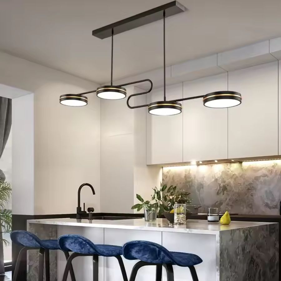 Suspension linéaire noire et dorée à quatre disques LED, au design moderne au-dessus d’un îlot de cuisine