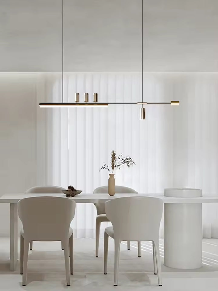 Suspension noire et dorée aux lignes fines et épurées, mise en valeur dans une salle à manger lumineuse et contemporaine