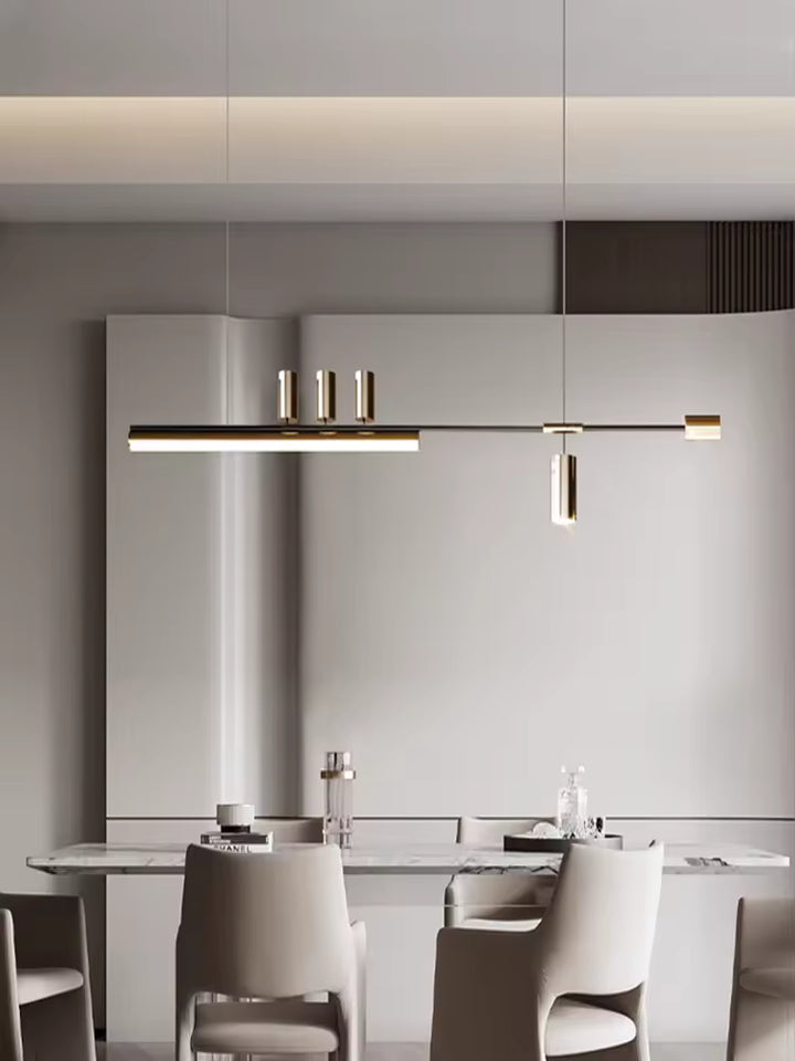 Élégante suspension linéaire noire et dorée au style minimaliste, mise en scène au-dessus d’une table de salle à manger