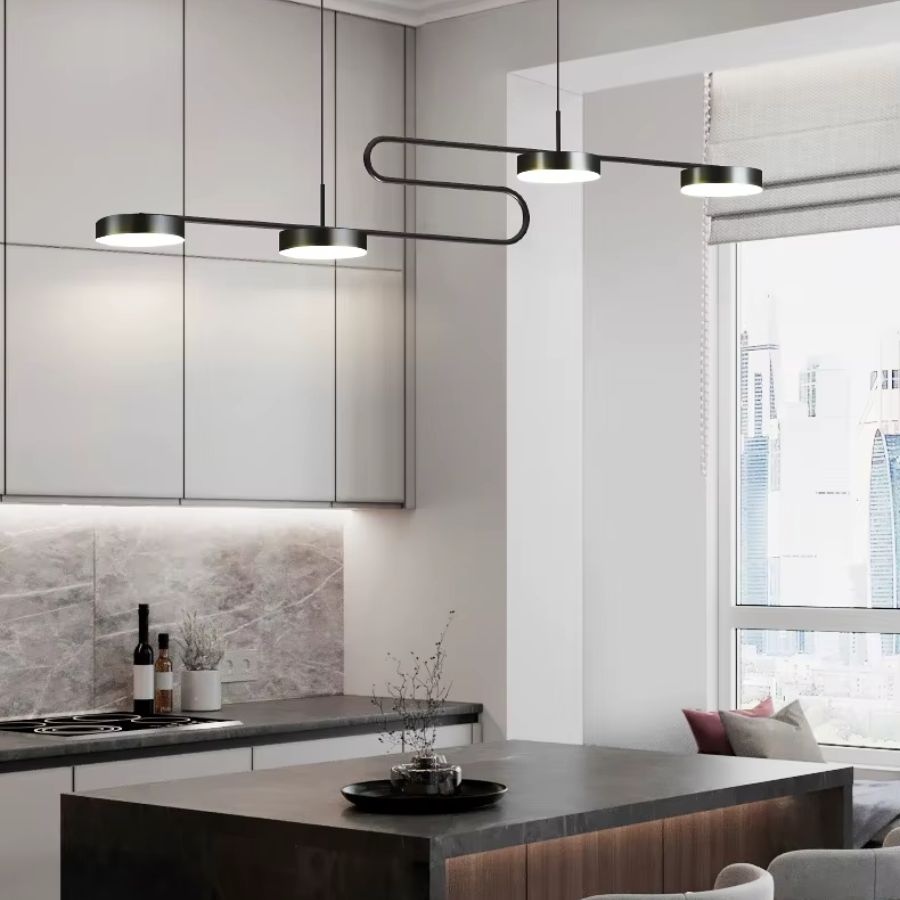 Suspension linéaire noire à double boucle et quatre disques LED, installée au-dessus d’un îlot de cuisine moderne