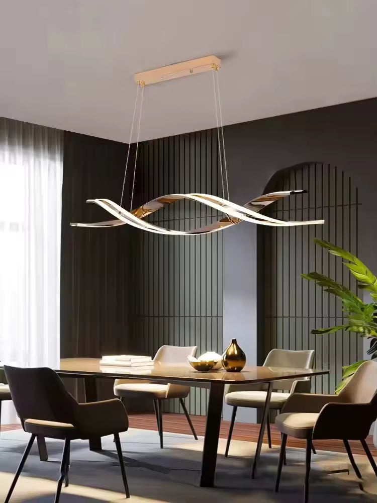 Des rubans LED dorés aux courbes entrelacées composent cette suspension design, installée dans une salle à manger élégante.