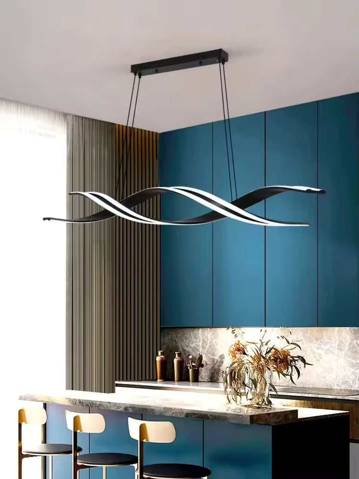Au-dessus d'un îlot de cuisine bleu, suspension noire à rubans LED entrelacés, aux lignes fluides et au design futuriste.