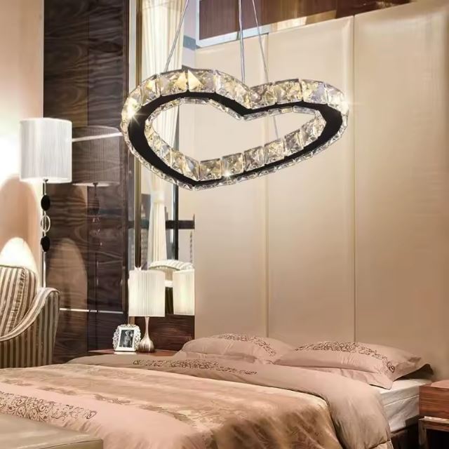 Suspension luminaire cœur en cristal, ajoutant une ambiance romantique et chaleureuse à une chambre élégante.