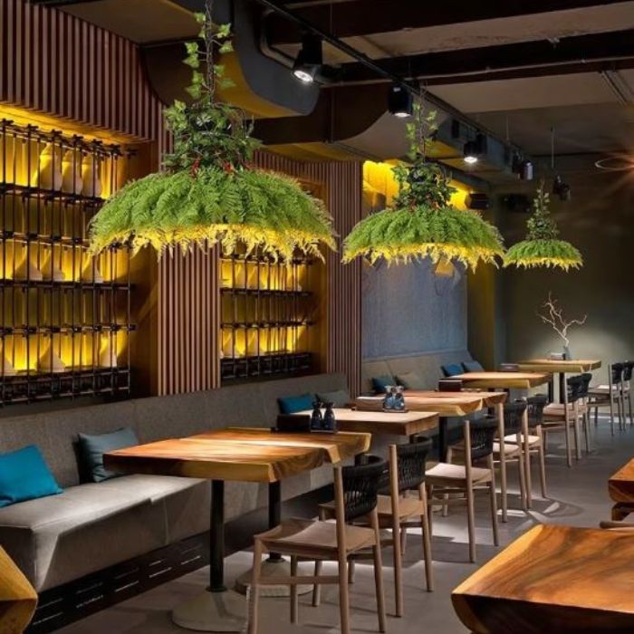 Suspensions luminaires végétales ornées de plantes décoratives, apportant une ambiance naturelle et chaleureuse dans un restaurant design.