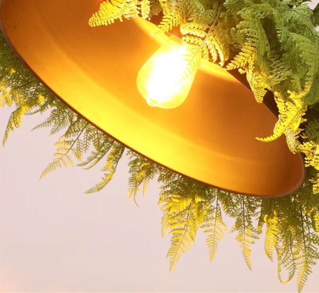 Détail de la suspension luminaire végétale et ampoule diffusant une lumière douce et naturelle.