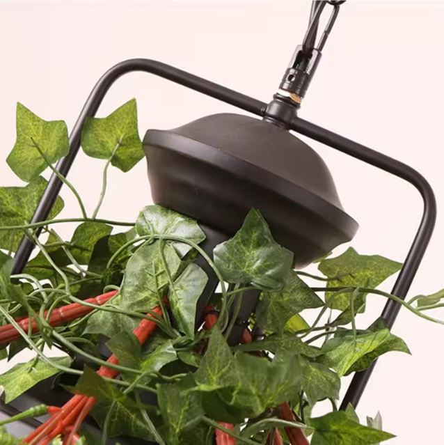 Détail de la suspension luminaire végétale avec ses plantes artificielles et sa structure noire au design naturel.