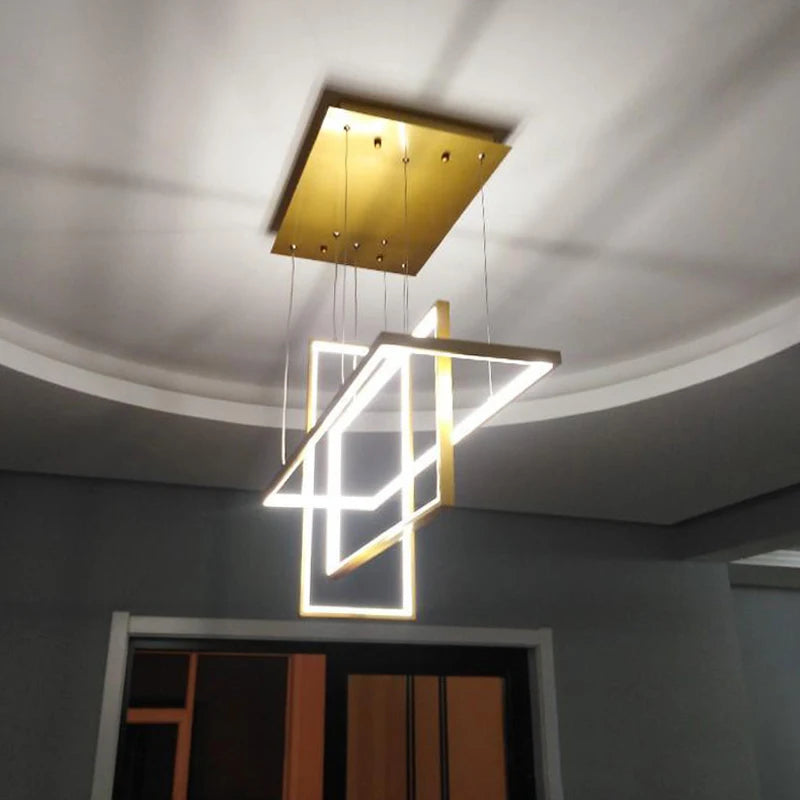 Suspension lumineuse au style art déco avec une finition dorée brillante et des lignes graphiques élégantes.