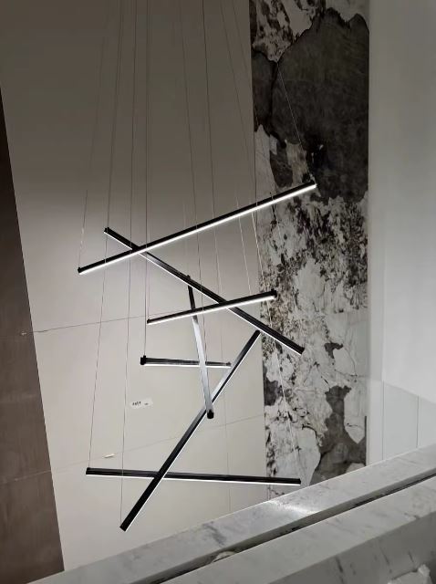 Suspension à tiges LED noires suspendues en cascade, idéale pour un intérieur moderne au style sculptural, graphique et audacieux.