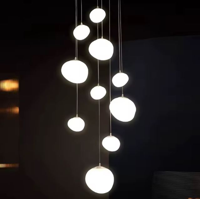 Grande suspension minimaliste pour cage d'escalier avec des sphères lumineuses, idéale pour un design moderne et épuré.