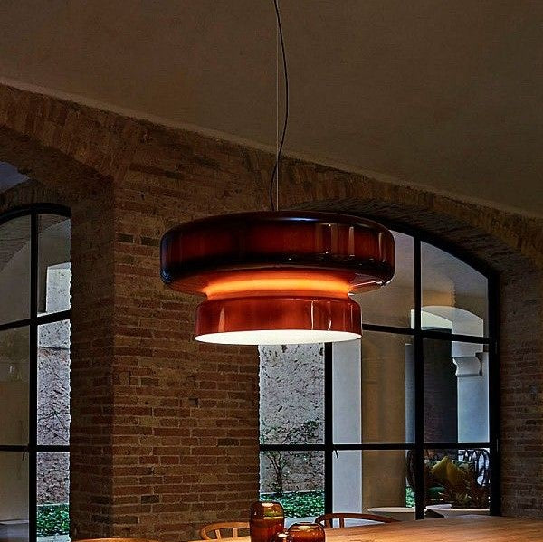 Suspension lumineuse moderne en verre fumé suspendue dans un loft au décor style industriel.