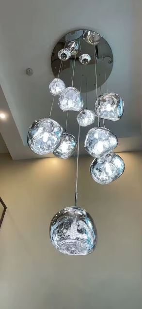 Lustre suspendu contemporain en galets de verre chromé, design sculptural idéal pour plafonds hauts et ambiance artistique moderne