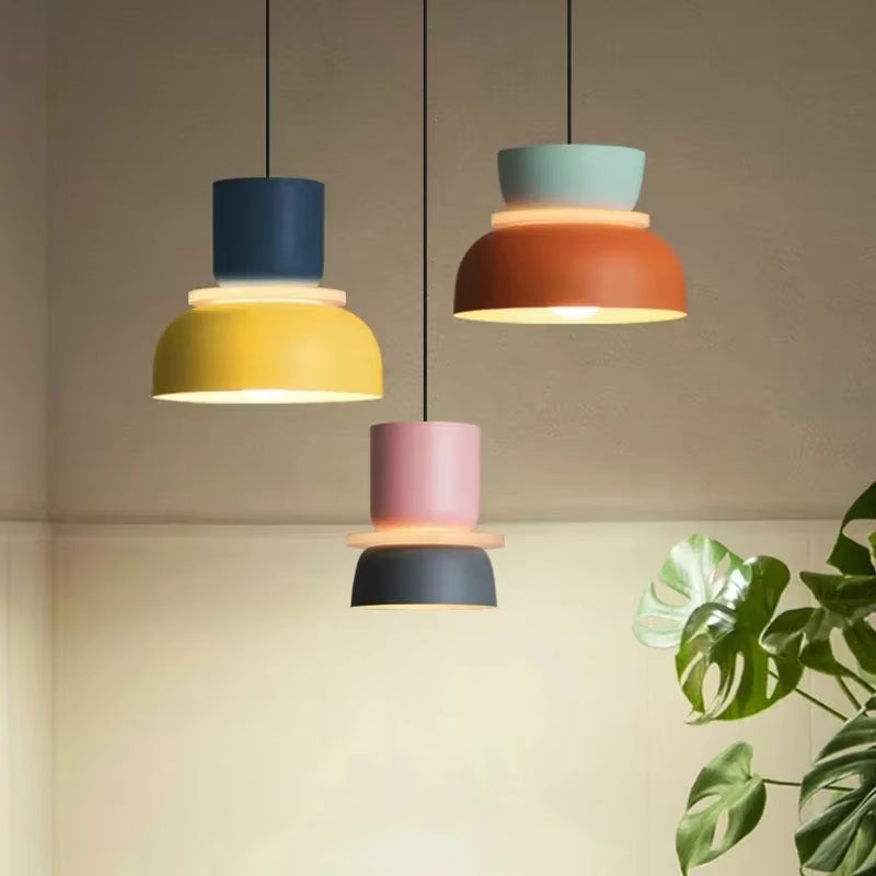 Luminaire suspension macaron aux teintes jaune, orange et rose, design rétro color block dans un intérieur contemporain