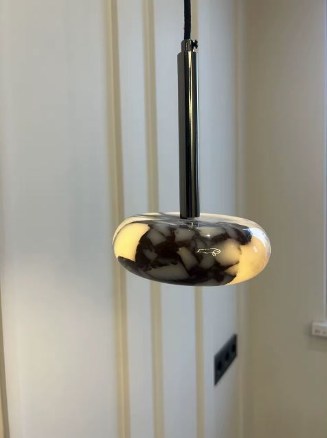 Suspension en marbre veiné au design contemporain, mettant en valeur la beauté naturelle de la pierre éclairée