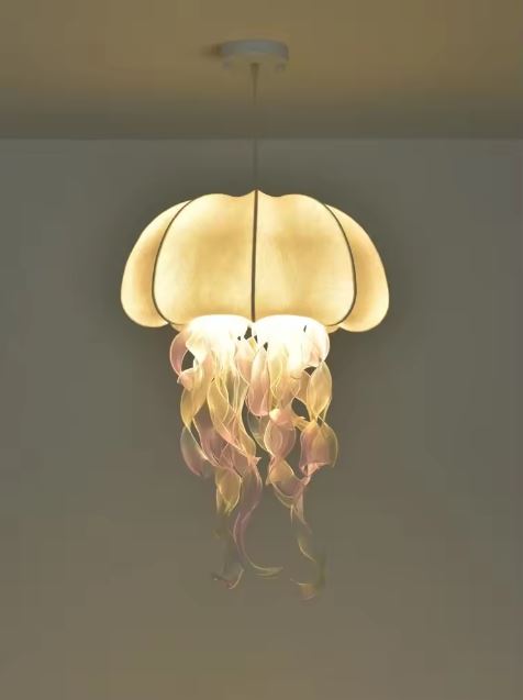 Suspension méduse lumineuse blanche avec filaments rose doré, esprit onirique et silhouette organique.