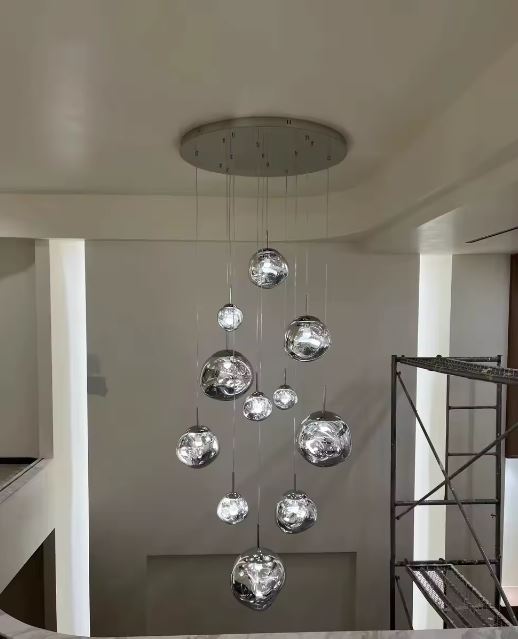 Suspension design galets effet miroir pour cage d’escalier ou entrée cathédrale, au style sculptural et éclat contemporain affirmé.