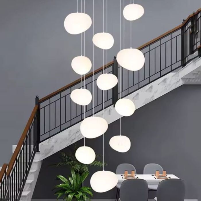 Grande suspension moderne et élégante pour cage d'escalier, composée d'abat-jours en acrylique lumineux et design.