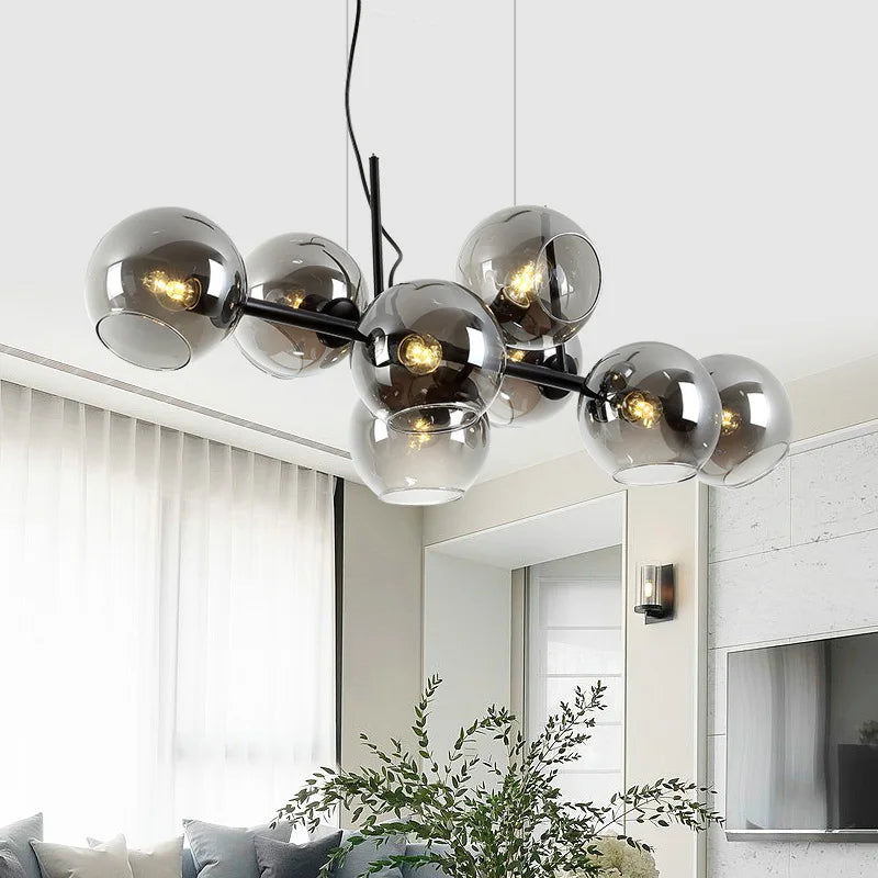 Grande suspension contemporaine aux globes de verre étagés installée dans une pièce de vie.