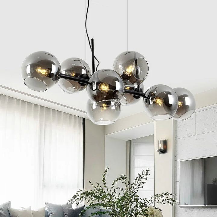 Grande suspension contemporaine aux globes de verre étagés installée dans une pièce de vie.