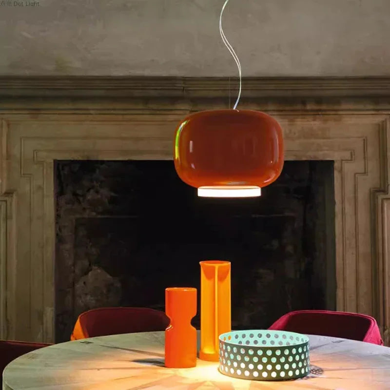 Suspension Monolithe Space Age orange laquée suspendue au-dessus d'une table ronde dans une salle à manger chaleureuse.