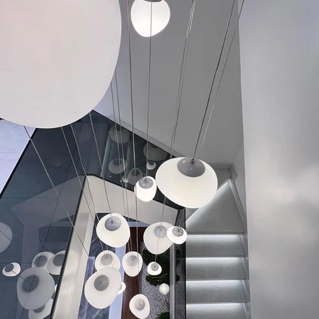 Suspension multiple blanche pour cage d’escalier moderne, luminaire contemporain aux sphères suspendues aériennes.