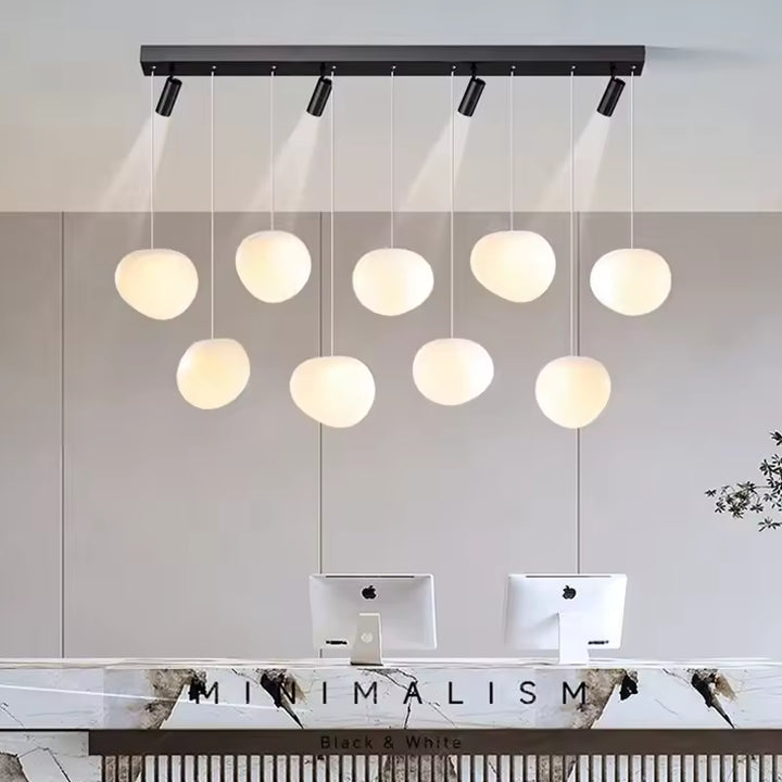 Dans un esprit design contemporain, plusieurs globes opalins s’associent à des spots orientables noirs