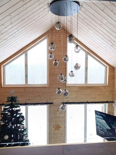Suspension multiple en verre pour escalier à plafond cathédrale, lustre contemporain en cascade au rendu spectaculaire.