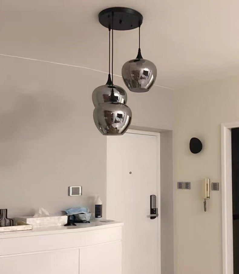 Élément de suspension en verre fumé isolé à 3 abat-jours, idéal pour un éclairage d'accentuation moderne.