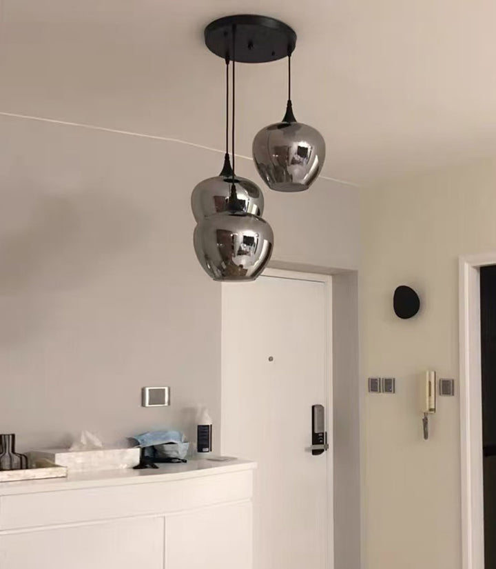 Élément de suspension en verre fumé isolé à 3 abat-jours, idéal pour un éclairage d'accentuation moderne.