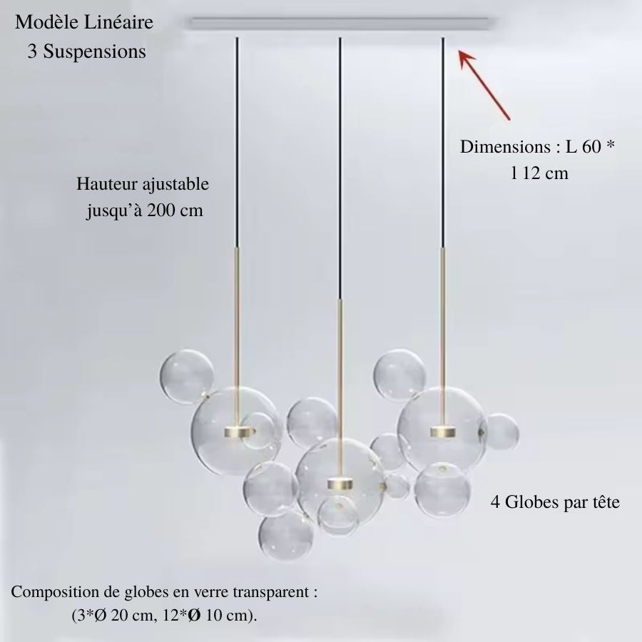 Alignement de trois suspensions en verre soufflé aux globes transparents, créant un luminaire contemporain et graphique.