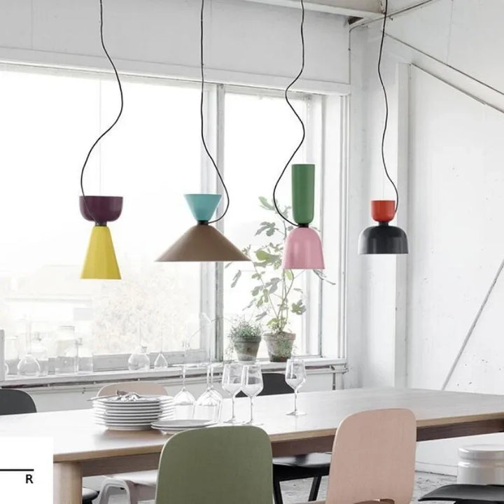 Installation de plusieurs suspensions géométriques colorées dans un grand espace de vie au style scandinave et moderne.