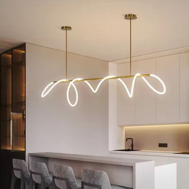 Suspension néon LED en forme d'ondulation dorée, parfaite pour illuminer un îlot de cuisine avec élégance.