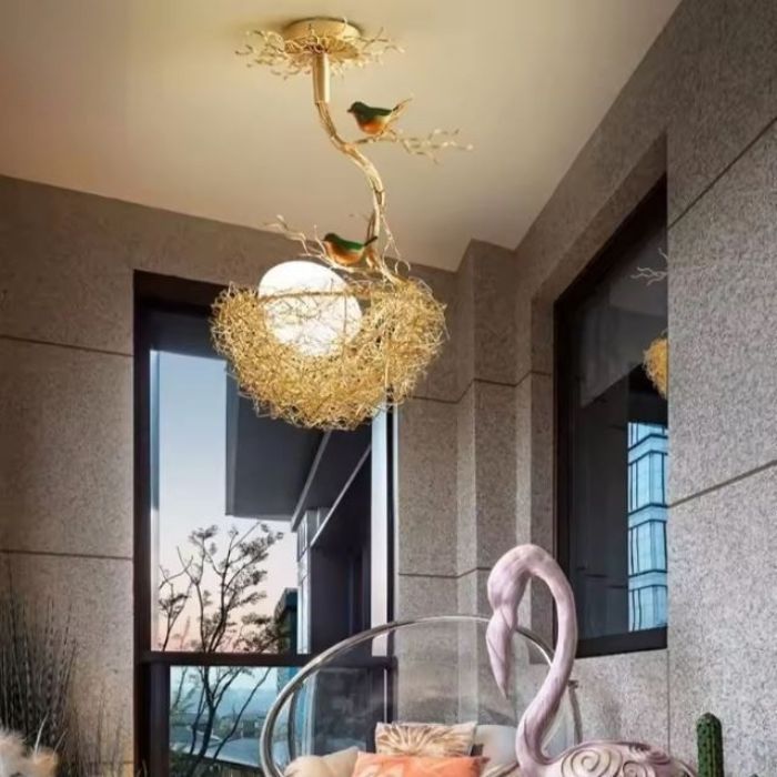 Suspension nid d'oiseau en métal doré avec oiseaux décoratifs, idéale pour décorer un balcon moderne.