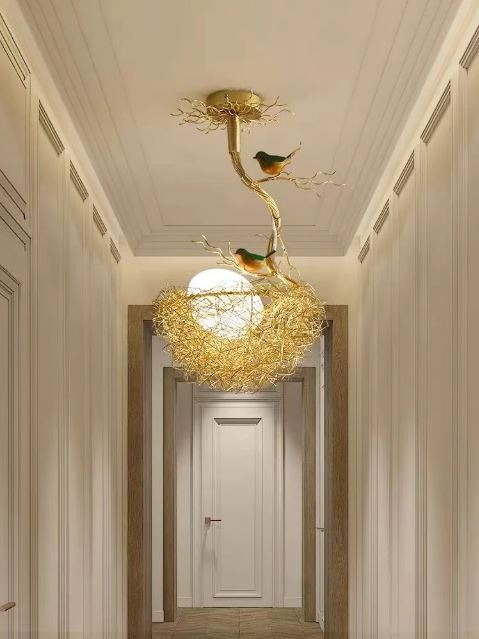 Suspension nid d'oiseau dorée avec sphère lumineuse blanche, parfaite pour illuminer un couloir raffiné.