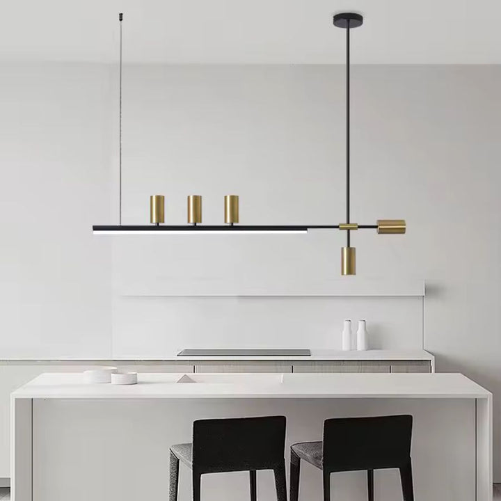 Suspension linéaire noire et dorée au style minimaliste et géométrique, installée au-dessus d’un îlot de cuisine moderne