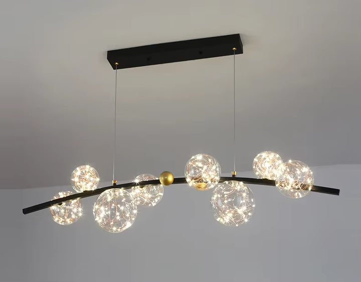 Suspension noire à globes en verre étoilé sur barre courbe, au design céleste moderne et graphique.